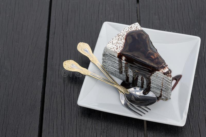oreo-crepe-cake-chocolate-white-dish-wooden-table-147073747